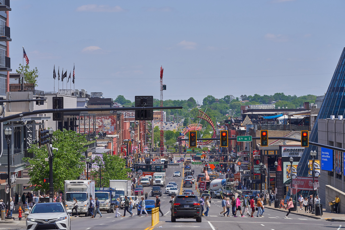 view of cars and pedestrians crossing Broadway in downtown Nashville, TN