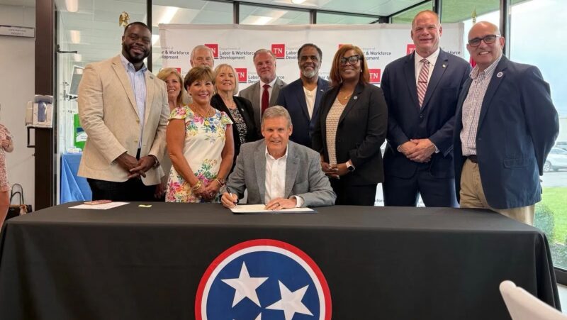 Governor Bill Lee signs workforce development bill surrounded by officials and community leaders in Tennessee.