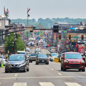 view of cars and pedestrians crossing Broadway in downtown Nashville, TN