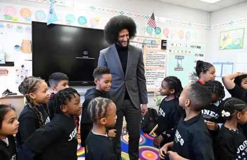 Colin Kaepernick, CEO and founder of Lumi, speaks with elementary students gathered around him in a classroom.