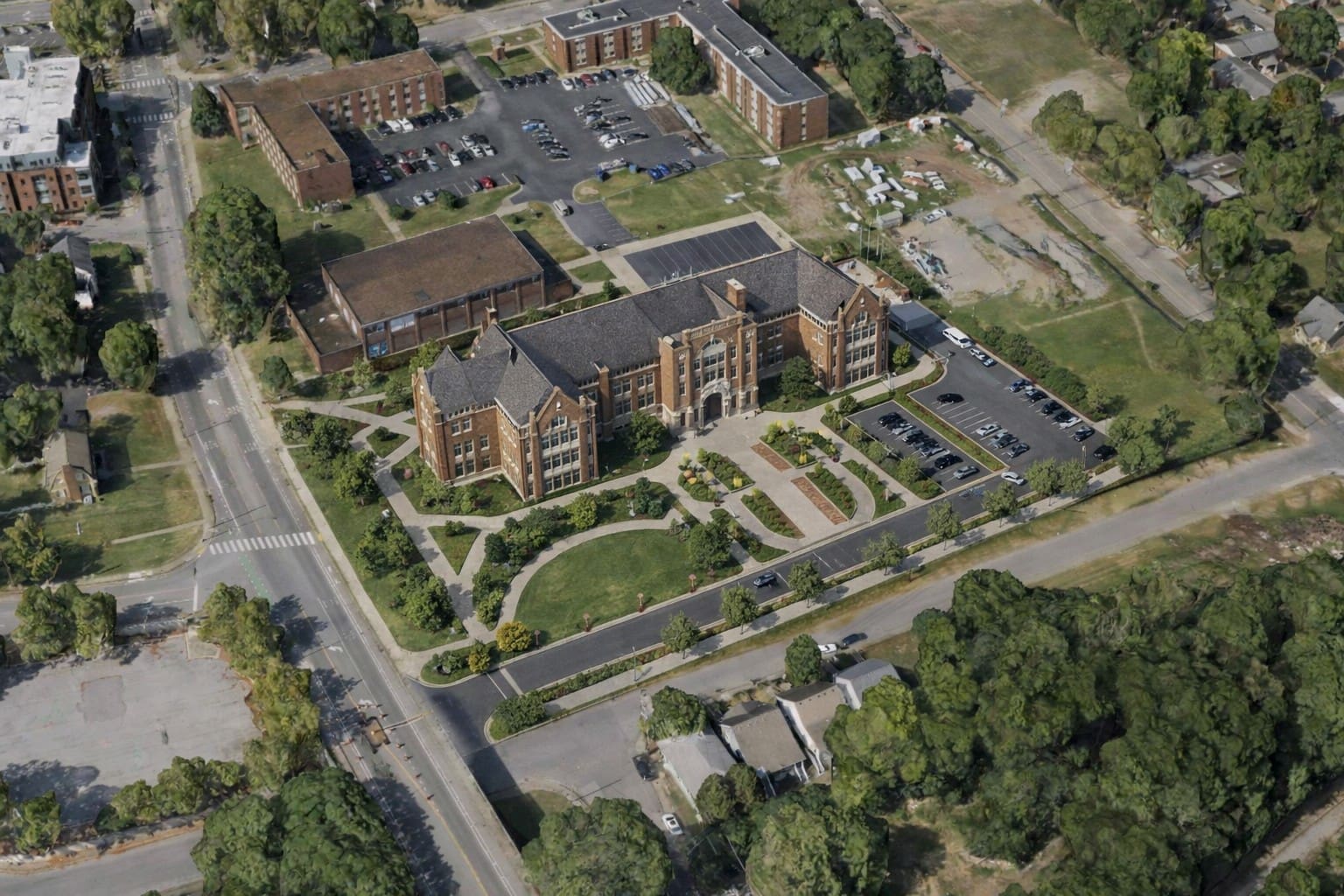 Aerial view of Fisk University, featuring a historic academic building surrounded by landscaped grounds, parking areas and neighboring campus buildings.